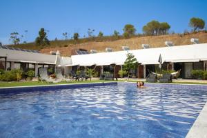 a woman swimming in the pool at a resort at Villa Atitudo Nature in Portimão