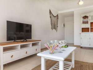 Una sala de estar con un televisor y una mesa blanca. en Apartment Guardamar by Interhome, en Miami Platja