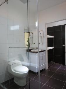 a bathroom with a toilet and a glass shower at Gran Hotel Internacional Sanbara in Arauca