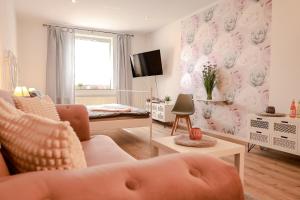 a living room with a couch and a tv at Pension Kastanie in Sehlen