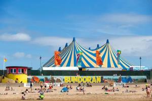 a circus tent on a beach with a crowd of people at Atlantic Point Stunning Sea View in Bundoran