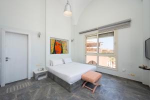 a bedroom with a white bed and a chair at VESTA - Soma Bay Residence in Hurghada