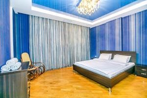 a bedroom with a bed with blue walls and a chandelier at Marina Luxury Apartment in Nizami st in Baku