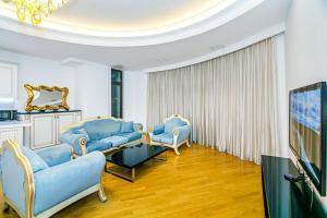 a living room with blue couches and a tv at Marina Luxury Apartment in Nizami st in Baku