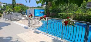 a blue fence with flowers on it next to a swimming pool at Hotel Yo in Saints Constantine and Helena