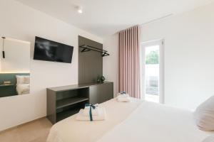 a hotel room with a bed and a television at Eleia Mirea in Monopoli