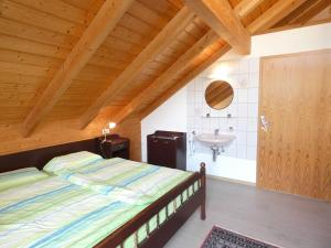 バート・ウーラッハにあるFerienhaus Christelのベッドと洗面台のある寝室