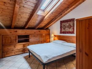 a bedroom with a bed in a room with wooden ceilings at Apartment Deliziosa Mansarda by Interhome in Ponte di Legno