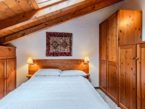 a bedroom with a large bed with wooden cabinets at Apartment Deliziosa Mansarda by Interhome in Ponte di Legno