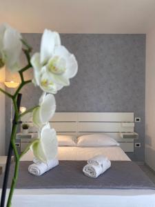 a bedroom with a bed with towels and a flower at Rimini Bay Suites&Residence in Rimini