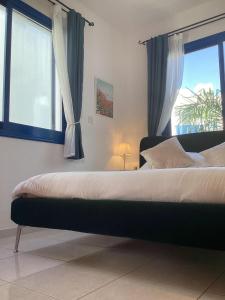 a bedroom with a large bed with a window at paphos pool view gem - cozy 1 bed Apartment in Paphos +34 photos