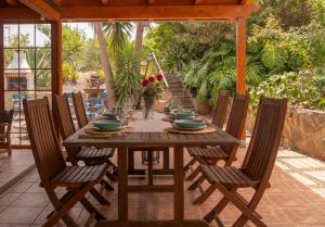 a wooden table and chairs on a patio at 6BR Fire House Sanctuary-Terrace & Barbacue in Santa Maria de Guia de Gran Canaria