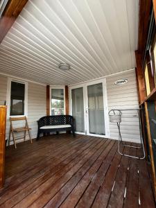 a porch with a bench on a wooden deck at Quinta da Mariazinha in Fernao Ferro