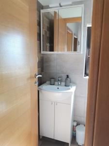 a bathroom with a white sink and a mirror at Apartment Ivana in Kastel Novi