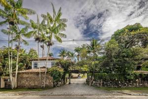 ein Haus mit Palmen und einer Steinzufahrt in der Unterkunft Relaxing & Modern House - Walking Distance from Historic Center of Paraty in Paraty