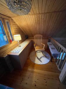 a room with a chair and a lamp in a cabin at Villa Kortepuro 