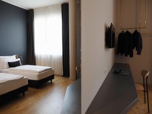 a hotel room with two beds and a desk at Bold Hotel München Giesing in Munich +20 photos
