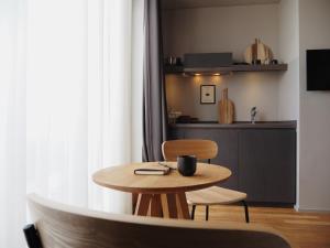 a table and chair in a room with a kitchen at Bold Hotel München Giesing in Munich