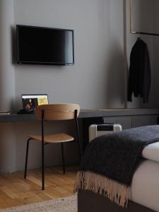 a bedroom with a bed and a desk with a chair at Bold Hotel München Giesing in Munich