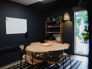 a dining room with a table and chairs and a whiteboard at Bold Hotel München Giesing in Munich