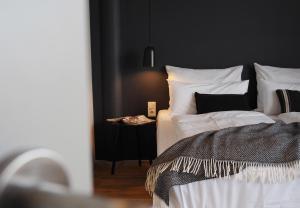 a bedroom with a bed with white sheets and pillows at Bold Hotel München Giesing in Munich
