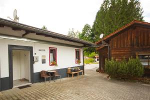 a building with chairs and a table in a courtyard at Chalet Waldstadl oder Andrea's Woidhaisl in Arnbruck