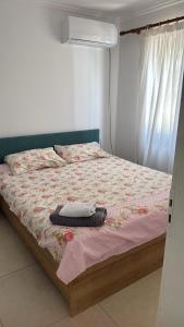 a bedroom with a bed with a blanket and a window at Dhoma Pushimi Tale Beach in Lezhë