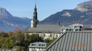 a large white church with a steeple in the mountains at La Comtesse in Saint-Gervais-les-Bains