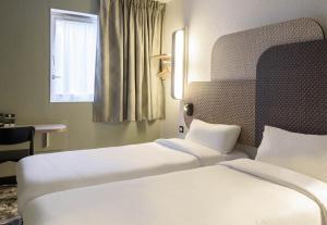 a hotel room with two beds and a window at B&B HOTEL Viry-Châtillon 3 étoiles in Viry-Châtillon