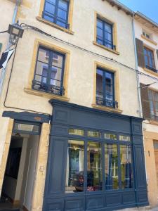 a store front with blue doors and windows at O'fil de soi e in Charlieu