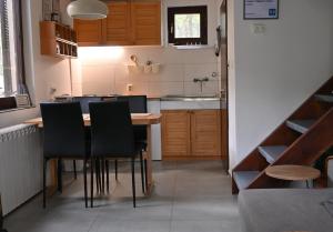 Una cocina con una mesa y sillas y un fregadero. en DIVCIBARE KUCA centar, en Divčibare
