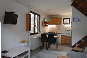 Una cocina con mesa y sillas y un televisor. en DIVCIBARE KUCA centar, en Divčibare