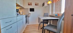 een kleine keuken met een tafel en een eetkamer bij Stadtdomizil am Binnensee, Haus Bellevue in Heiligenhafen