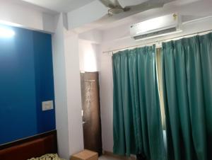 a room with a green curtain and a fan at RL Residency in Jāmb