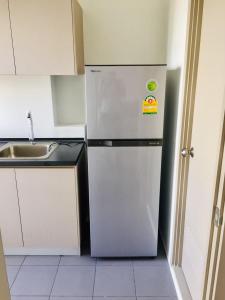 a white refrigerator in a kitchen with a sink at Great facilities n River view n Local in Ban Sai Ma