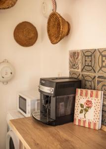 a black coffee maker on a counter next to a microwave at Pista bácsi háza in Pusztaföldvár