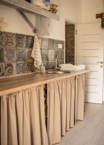 a kitchen with a sink and a counter with curtains at Pista bácsi háza in Pusztaföldvár