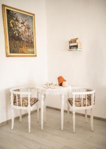 a table and two chairs in a room with a painting at Pista bácsi háza in Pusztaföldvár