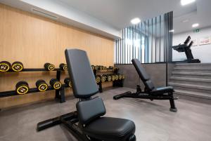 a gym with two chairs and dumbbells at Rewal Cozy Apartment with Parking, Gym, Spa & Pool close to the Beach by Noclegi Renters in Rewal +36 photos