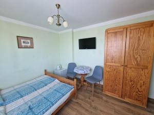 a bedroom with a bed and a table and chairs at Pensjonat Elżbieta in Łeba +42 photos
