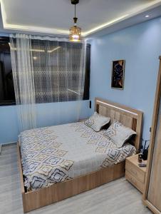 a bedroom with a bed and a window at La maison bleu in Oulad Akkou +15 photos
