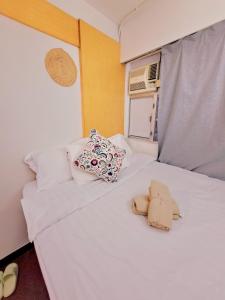 a bedroom with a white bed with a stuffed animal on it at Cozy full Apartment 2 bedroom central area in Hong Kong