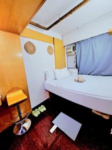 a small room with a bed and a chair at Cozy full Apartment 2 bedroom central area in Hong Kong