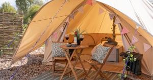 蒂克纳尔Broadleaves Luxury Glamping的帐篷前配有桌椅