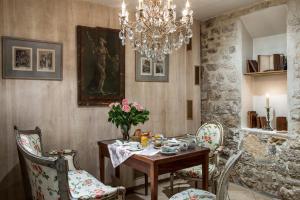 a dining room with a table and chairs and a chandelier at Hotel Caron de Beaumarchais in Paris