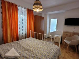 a bedroom with a bed and a tv and a window at Vila Didi, Mangalia in Mangalia