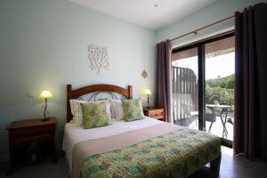a bedroom with a large bed and a balcony at Villa Atitudo Nature in Portimão +70 photos