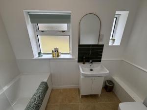 ein Badezimmer mit Waschbecken, Badewanne und Spiegel in der Unterkunft Altchourunn Cottage in Acharra + 17 Fotos