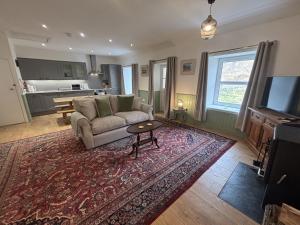 ein Wohnzimmer mit einer Couch und einem Teppich in der Unterkunft Altchourunn Cottage in Acharra