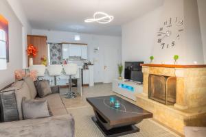 ein Wohnzimmer mit Sofa und Kamin in der Unterkunft Sunset Waves in Menídion